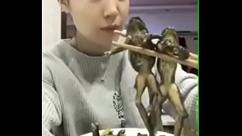 いくつかのアマガエルを食べるアジア人