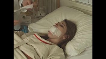 ベッド病院に縛られた 衣テープの口のかなりブルネット