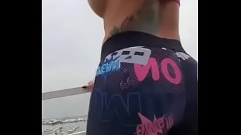 テラスで彼女のお尻とおっぱいを見せているスペインの売春婦