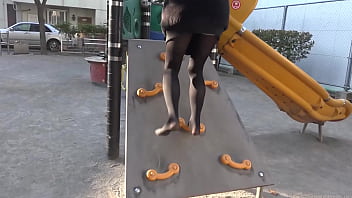 女の子は黒いタイツで公園の砂の上を歩く