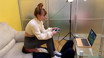 灰色のレギンスを着たゲーマーガールのキラは、フルウェイトの顔面騎乗中にプレイ中に椅子の奴隷を使用します（プレビュー）