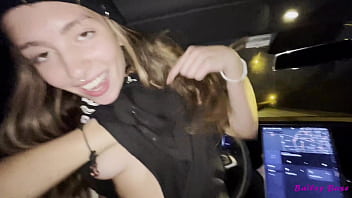 テスラの車が夜に通りを運転している間、暑い日をクソ