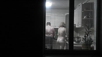 のぞき。盗撮。キッチンの裸のセクシーな隣人が彼女の夫のために夕食を準備しているので、通りの夜の隣人の変態盗撮は窓の外を見ます。公共の場で裸。家で全裸。家族。屋外