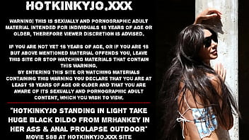 光の中に立っている Hotkinkyjo は、彼女のお尻の mrhankey から巨大な黒いディルドを取り、屋外で肛門脱を行います
