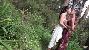 細い黒檀のひよこと巨乳のブルネットの間の森での屋外異人種間のレズビアンセックス