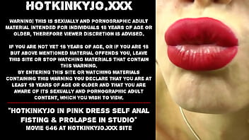 ピンクのドレスを着た Hotkinkyjo がスタジオでセルフ アナル フィスティング & 脱出